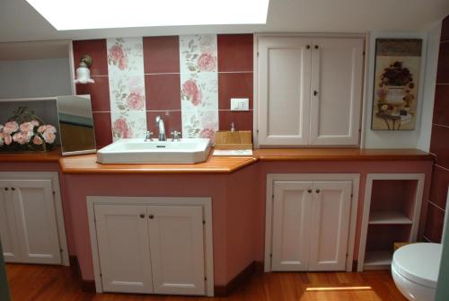 uma casa de banho com lavatório e azulejos vermelhos e brancos em B&B Antegiano em Belforte del Chienti