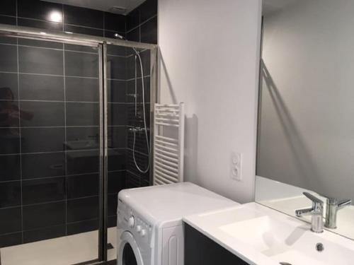 eine Waschmaschine im Bad mit Dusche in der Unterkunft Maison rénovée au calme in Gujan-Mestras