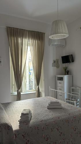 a bedroom with a large bed with towels on it at Sfumature Partenopee in Naples