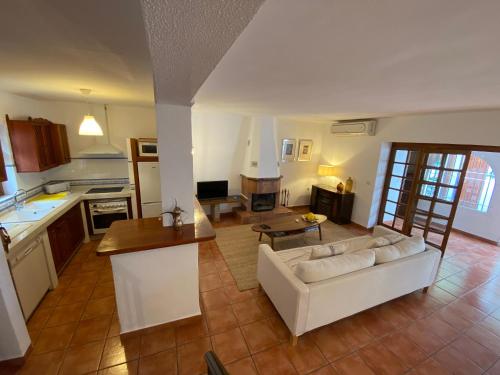 a living room with a white couch and a kitchen at Fuengirola pueblo 2BRD townhouse in Fuengirola