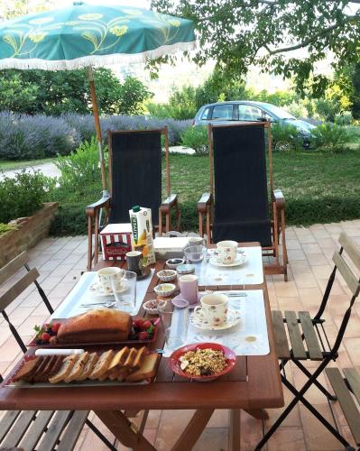 a table with food on it with an umbrella at B&B Antegiano in Belforte del Chienti