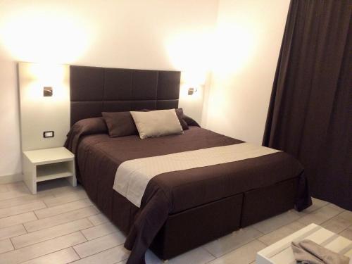 Schlafzimmer mit einem großen Bett mit einem schwarzen Kopfteil in der Unterkunft Ape in Marina di Schiavonea