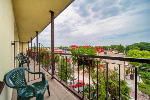 a balcony with two chairs and a view of a city at Hotel Gromada Medical SPA Busko Zdrój in Busko-Zdrój