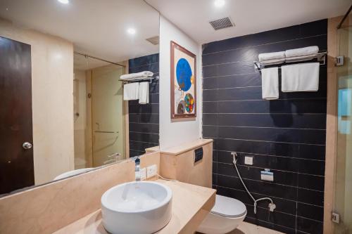 a bathroom with a sink and a toilet and a mirror at Saltstayz Malcha - Chanakyapuri in New Delhi