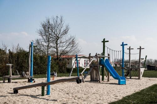 um parque infantil com escorrega na areia em Chalet Zeeuws Genieten in Baarland, Zeeland em Baarland