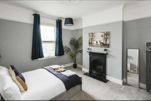 um quarto com uma cama grande e uma lareira em Spacious 4 bed house in Croydon with parking for x2 cars! - Photo ID & Deposit required em South Norwood