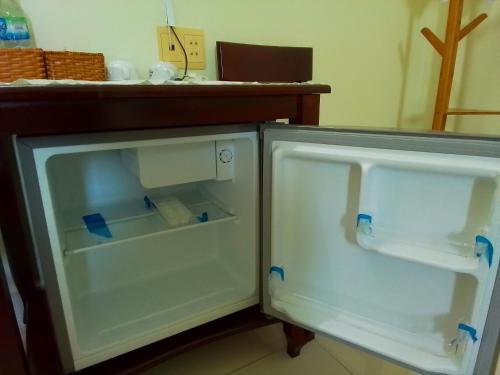 an empty refrigerator with its door open next to a counter at Hostel Đặng Lợi ホステルダンロイ in Chau Doc