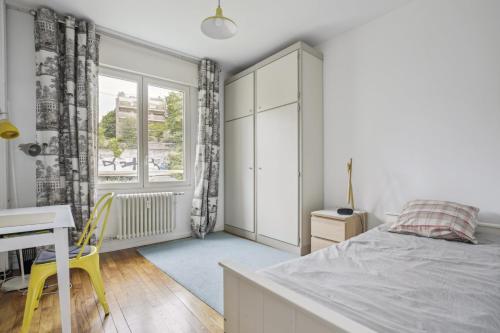 a bedroom with a bed and a desk and a window at Le Saint-Cloud Chic in Saint-Cloud