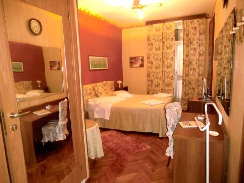 Habitación de hotel con cama y espejo en HOTEL SARA, en Turín