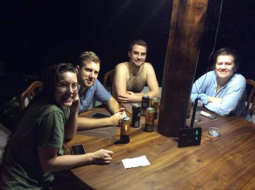 a group of people sitting around a wooden table at Cozy Homestay Kandy in Kandy