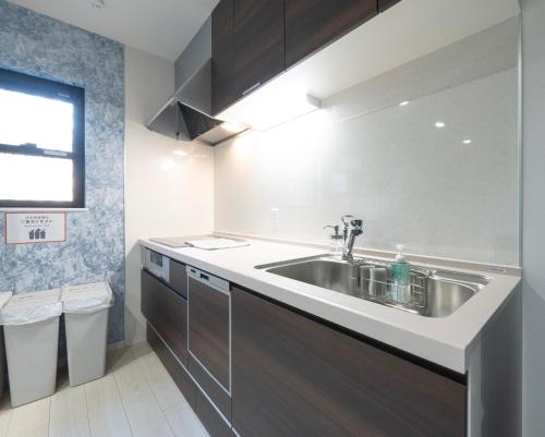 a kitchen with a stainless steel sink in a room at Rei Garden Resort in Kanayama