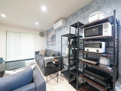 a living room with a couch and a tv at Rei Garden Resort in Kanayama