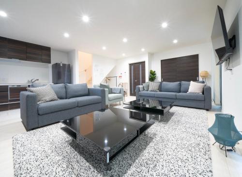 a living room with two couches and a table at Rei Garden Resort in Kanayama
