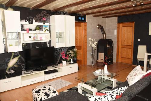 een woonkamer met een tv op een wit entertainmentcentrum bij Ferienhaus Herby in Bad Zwesten