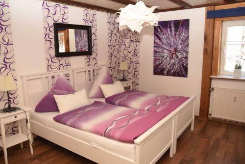 een bed met paarse kussens in een kamer bij Ferienhaus Herby in Bad Zwesten