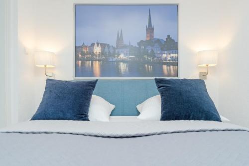 a bedroom with a bed with blue pillows and a picture at Fischerhus in Timmendorfer Strand