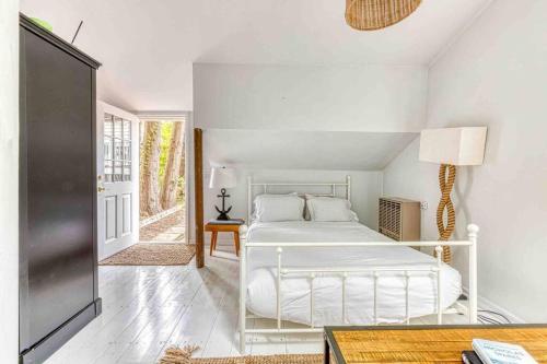 Un dormitorio blanco con una cama blanca y una ventana en East Hampton House- Heated Pool, Gym, Full Fence, en East Hampton