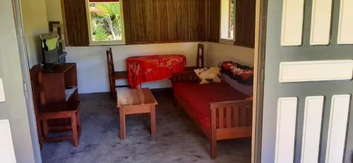 uma sala de estar com um sofá vermelho e uma mesa em VILLA HORTENSE em Ambodifototra