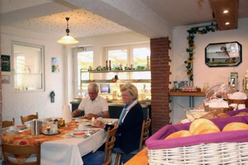zwei Personen sitzen an einem Tisch in einem Restaurant in der Unterkunft Restaurant-Pension Bürgerhof in Bad Zwesten