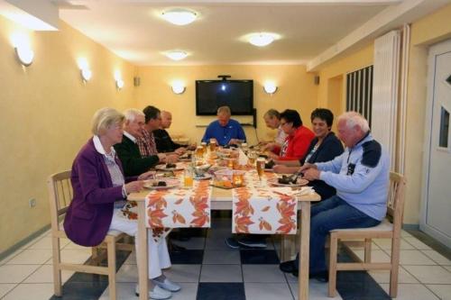 Eine Gruppe von Menschen, die an einem Tisch sitzen und essen in der Unterkunft Restaurant-Pension Bürgerhof in Bad Zwesten