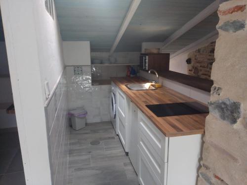 eine kleine Küche mit einer Spüle und einer Theke in der Unterkunft CASA CARMELA in Higuera de la Sierra