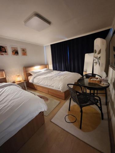 1 dormitorio con 2 camas, mesa y silla en You Here,Stay - 5min to Hapjeong Station, 10mins to Hongdae en Seúl