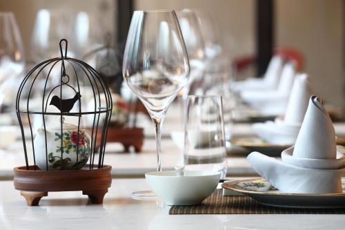 a table with wine glasses and a bird cage on it at LN Hotel Five in Guangzhou