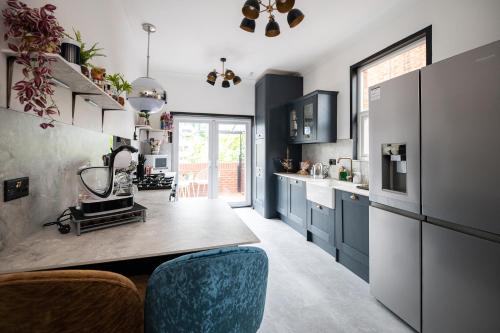 a kitchen with blue cabinets and a counter at Flawsome Stays Unique Home w Quirky basement for 12 Guests by Harbour and Town in Ramsgate