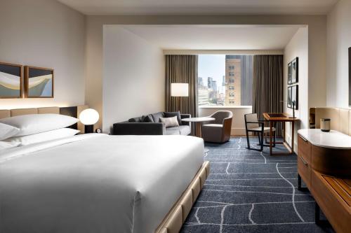a hotel room with a bed and a living room at Park Hyatt Toronto in Toronto