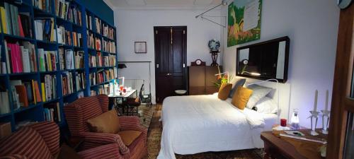 um quarto com uma cama e uma estante de livros com livros em Jardin secreto en el centro de Barcelona 2 em Barcelona