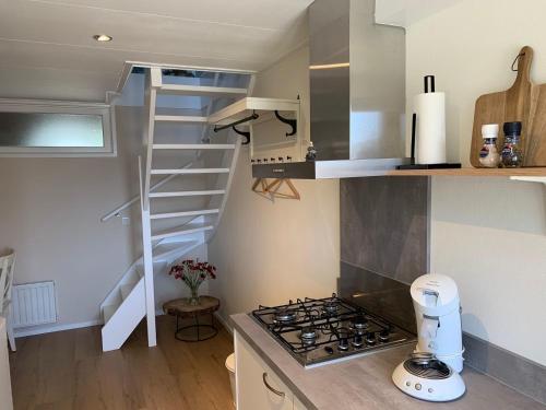 una pequeña cocina con fogones y una escalera de caracol en Studio 8, en Zoutelande