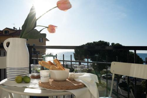 a table with a plate of bread and a vase at Vayadù Etoile House in Ospedaletti
