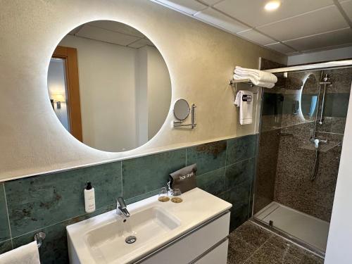 a bathroom with a sink and a mirror and a shower at Antídoto Rooms Zocodover in Toledo