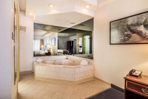 a large bath tub in a bathroom with a mirror at Quality Inn & Suites Albany Airport in Latham