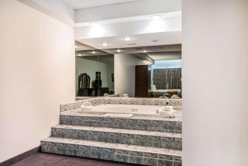 a bathroom with a tub and stairs with a mirror at Quality Inn & Suites Albany Airport in Latham