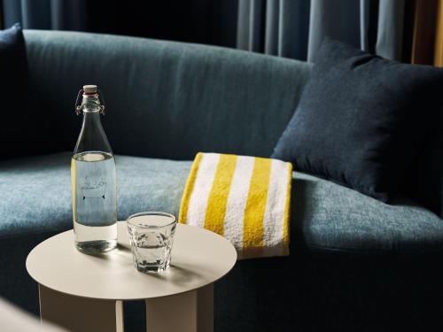 a bottle and glass on a table next to a couch at Urban Nature Bad Gastein - Badeschloss in Bad Gastein