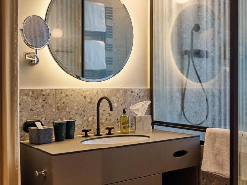 a bathroom with a sink and a mirror at Urban Nature Bad Gastein - Badeschloss in Bad Gastein
