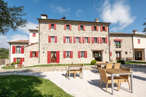 a large stone building with tables and chairs in front of it at Agriturismo Althea in Vittorio Veneto