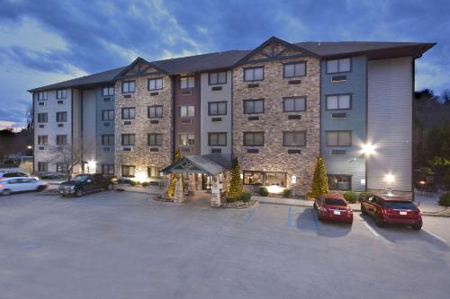 a large building with cars parked in a parking lot at Brookstone Lodge near Biltmore Village, an Ascend Collection Hotel in Asheville