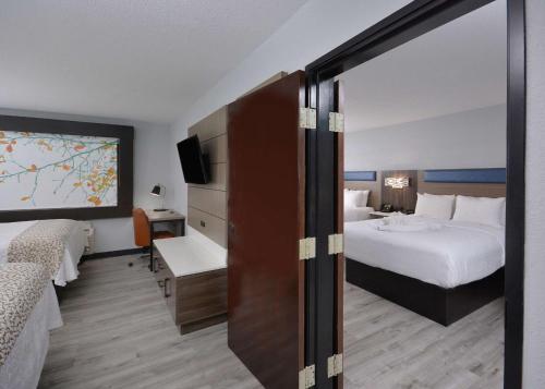 a hotel room with a bed and a tv at Brookstone Lodge near Biltmore Village, Ascend Hotel Collection in Asheville