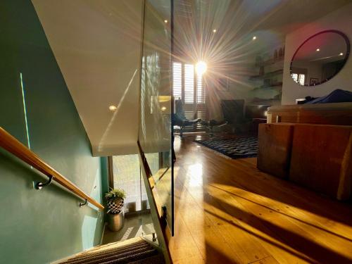 a room with a light shining through a glass wall at Modern Seaside Townhouse feat Sauna near Brighton in Shoreham-by-Sea