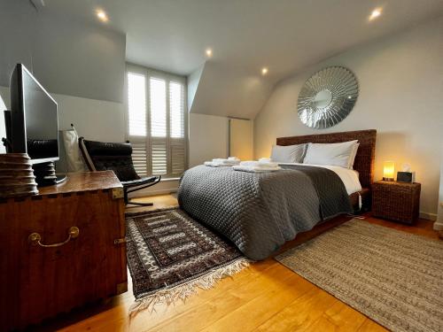 a bedroom with a bed and a flat screen tv at Modern Seaside Townhouse feat Sauna near Brighton in Shoreham-by-Sea