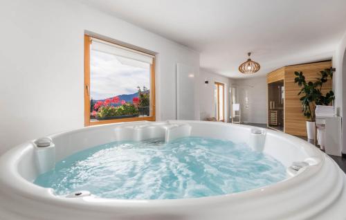 a large bath tub in a bathroom with a window at Holiday Home & Spa Kozji Vrh in Čabar