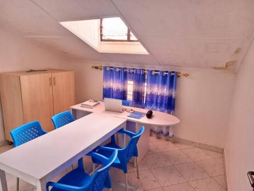 a room with a white table and blue chairs at Storm Executive in Kilifi