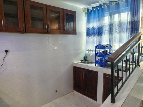 a kitchen with a sink and a staircase next to a window at Storm Executive in Kilifi