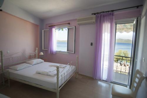 a bedroom with a bed and a large window at Giorgio Apartments in Nikiana