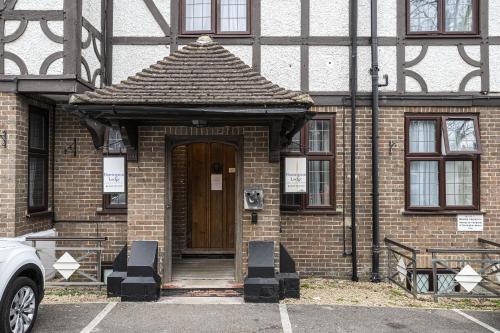 a brick building with a wooden door in front at Barrington Lodge in Crawley