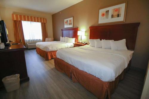 Habitación de hotel con 2 camas y TV en Seffner Inn and Suites, en Seffner