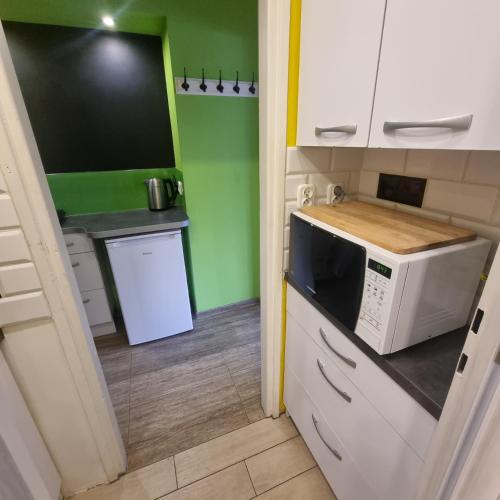 una cucina con forno a microonde e una cucina con pareti verdi di Orange Apartment Kraków a Cracovia