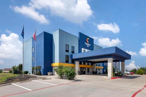 Um edifício azul com uma bandeira americana à frente. em Comfort Inn - Weatherford em Weatherford